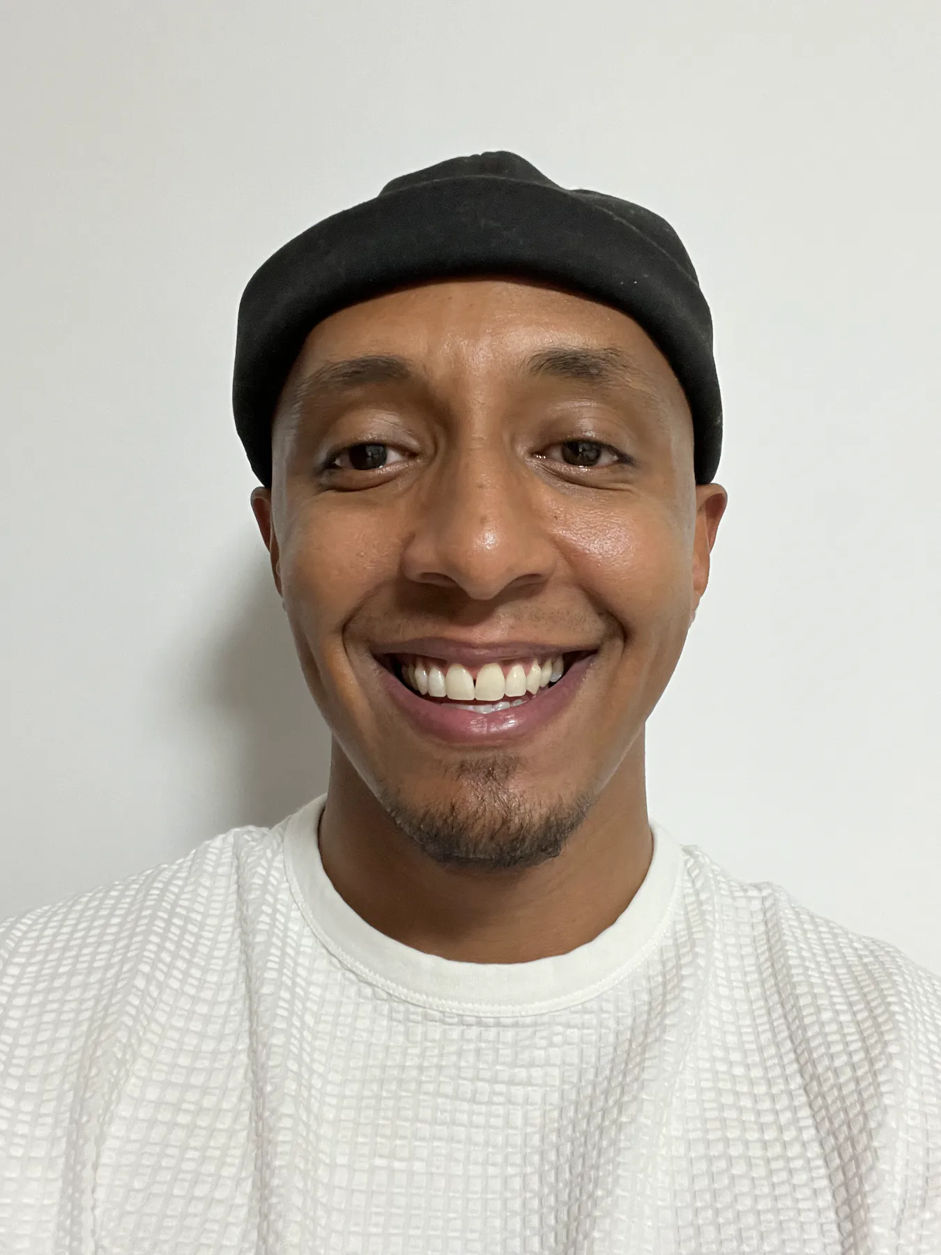 Samatar Elmi smiling in a black cap